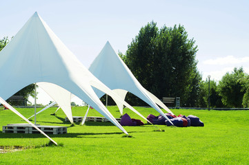 A white tent or marquee in a green field.  Tent awning Star, star tent, outdoor activities, events,...
