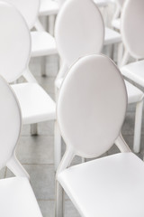 background of row of white seats. Empty chairs in the conference hall.