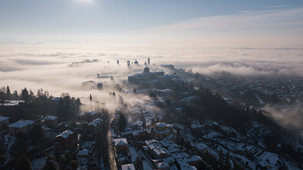 Bergamo, Italy. Drone aerial view of an amazing landscape of the fog rises from the plains and covers the old town