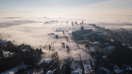Bergamo, Italy. Drone aerial view of an amazing landscape of the fog rises from the plains and covers the old town