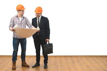 The engineer and a businessman stand with a paper on the white wall background