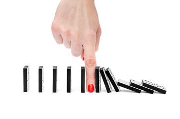 Woman's hand stopping domino effect on white background.