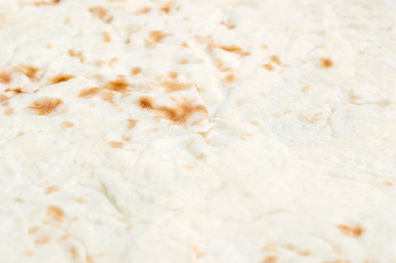 The texture of baked thin flatbread. Close up.