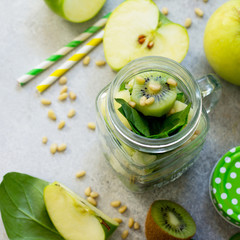 Ingredients for the preparation of green smoothies - apple, kiwi, spinach, pine nuts. Healthy vegan food concept. Copy space.