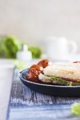 Homemade toast with beef, cheese and sauce, grilled with cherry tomatoes.