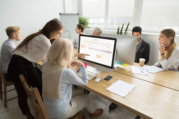 Young manager teaching senior worker explains planning work in office, corporate teacher helps...