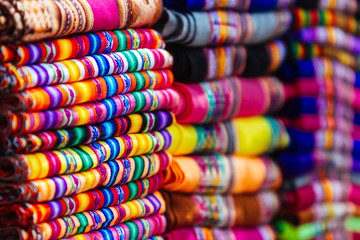 Fototapeta na wymiar Macro close-up of colorful blankets stacked with Andean designs