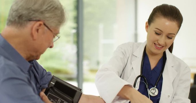 4K Friendly female doctor giving medical check to cheerful senior man