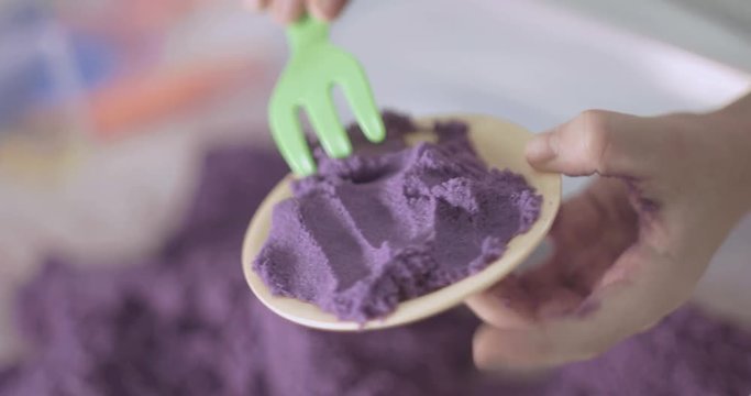 little girl plays with kinetic sand