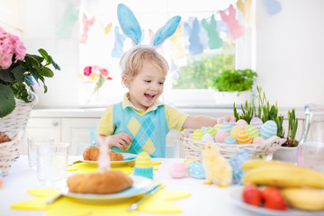 Kids at Easter breakfast. Eggs basket, bunny ears.