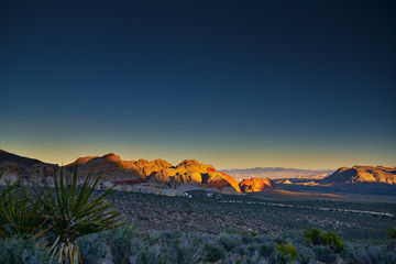 sun setting over redrock canyon rocks with las vegas in background © Joshua Resnick