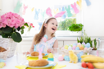 Kids at Easter breakfast. Eggs basket, bunny ears.