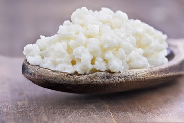 Fresh Kefir grains in wooden spoon. Kefir is one of the top health foods available providing...