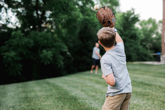 Father And Son Playing Baseball In The Backyard