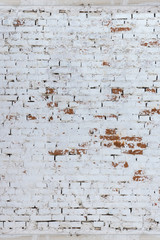 Brick wall whitewashed by lime, dirty and rubbed, traces of brush