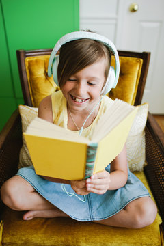 Young girl reading along while listening to a book