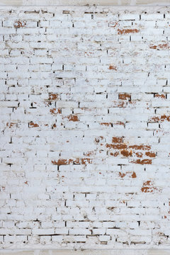 Brick wall whitewashed by lime, dirty and rubbed, traces of brush