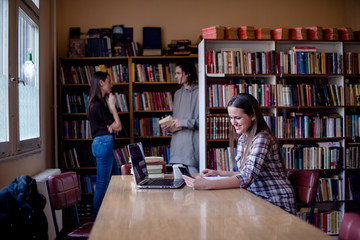 Student using mobile phone in library