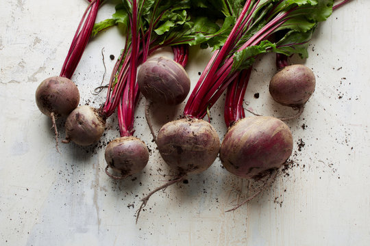 Bunch of fresh red beet vegetables on an old painting board as background