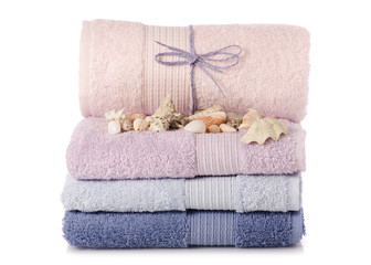 Fototapeta na wymiar A stack of towels pink blue spa sea seashell stones