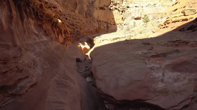 Hiking point of view over slot canyon in the desert of Utah with half in the shadow and half in the sunlight.