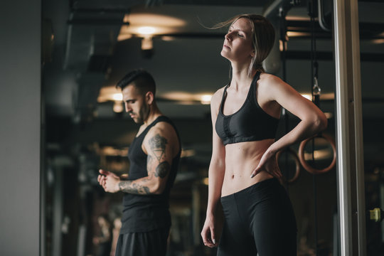 Man And Woman Resting In Gym After Workout