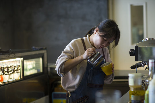 One young asian woman making caffee in the cafe