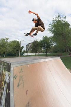 Male teenager performing midair tricks with skateboard