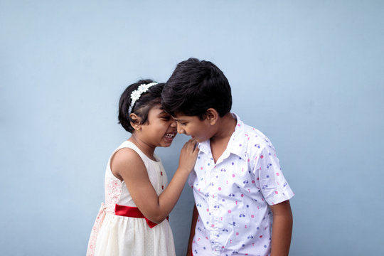 Little girl sharing a secret with her elder brother,having fun