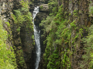Obraz premium Braemore, Scotland - June 8, 2012: Closeup of waterfall of Corrieshalloch Gorge, a deep cut in landscape with forested vertical slopes. Landscape photo.