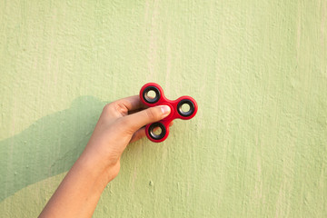 Girl Holding Fidget against green wall