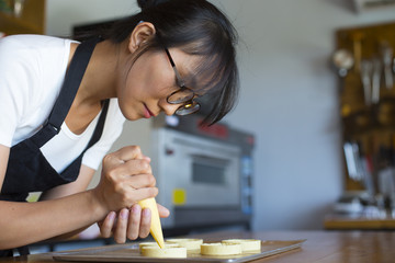 Young asian woman learning to make dessert in the kitchen
