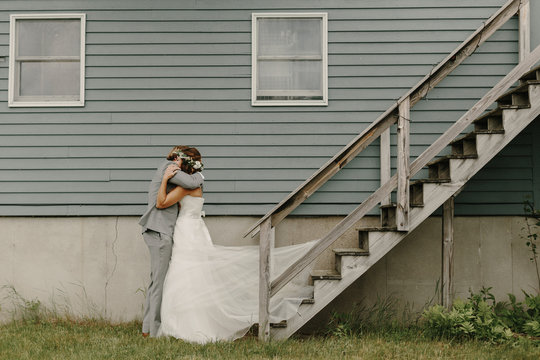 Bride and Groom Hugging in front of a House