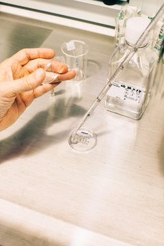 Closeup of Male Scientist Using a Pipette in a Fertility Clinic