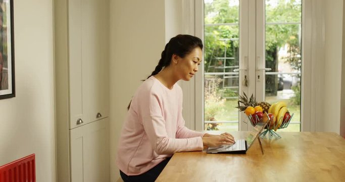 4K Woman at home using digital tablet with attached keyboard. Slow motion.