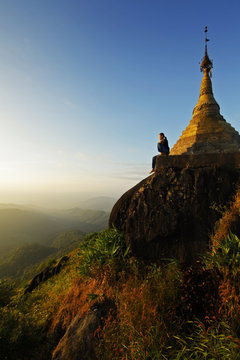 A young asian woman sitting at the Golden Rock