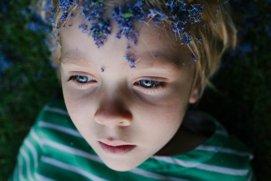 Little girl with Lilac petals on her head plays at dusk.