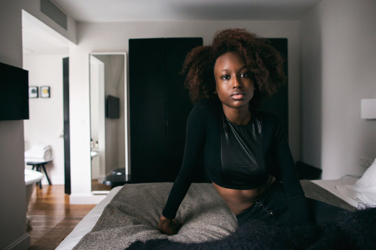 Portrait of Pretty Young African Readhead Sitting on Bed
