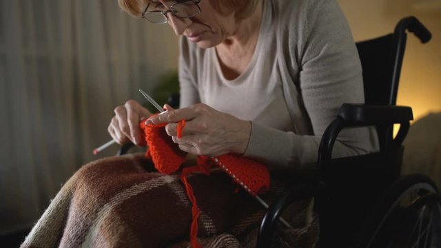 Old knitting woman feeling desperate of shaking hands illness, hopelessness