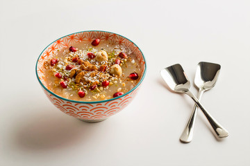 Traditional Turkish dessert Ashura (Noah Puding) in classic bowl on the white background.Close up...