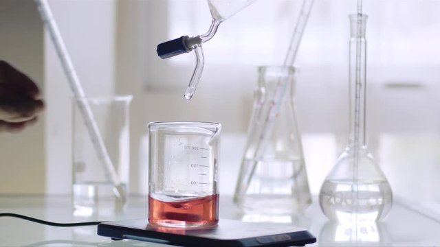 Scientist working with chemical reaction in an Erlenmeyer flask in chemical laboratory