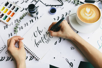 Hands writing with ink in notepad