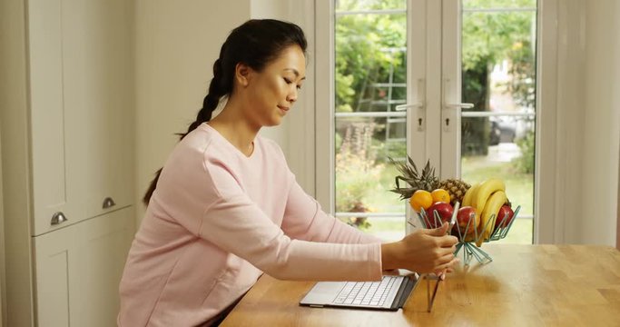 4K Beautiful woman attaching keyboard to digital tablet at home, using the internet for business or leisure. Slow motion.