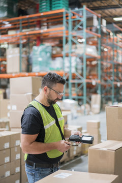 Warehouse worker using hand held scanner