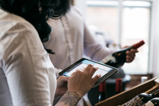 Wine: Owner And Employee Taking Inventory With Digital Tablet