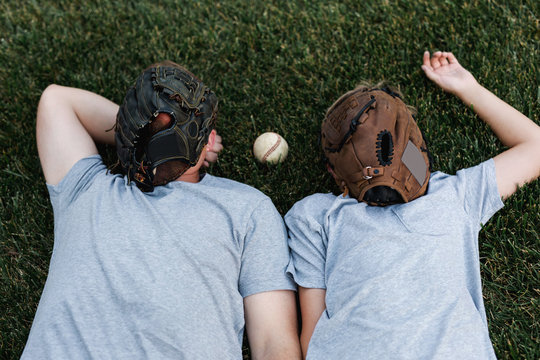 father and son take a break from playing catch in the backyard