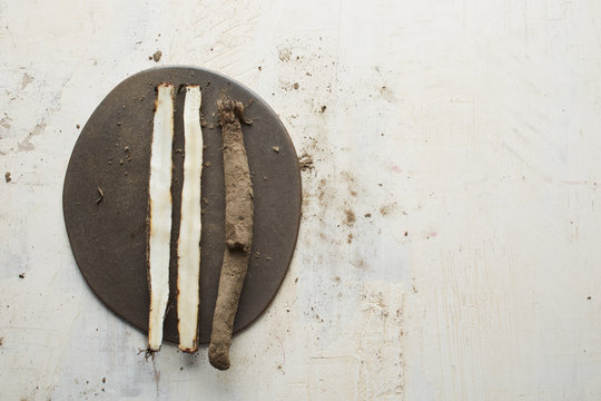 Cut salsify roots on a ceramic plate and old painted board as background