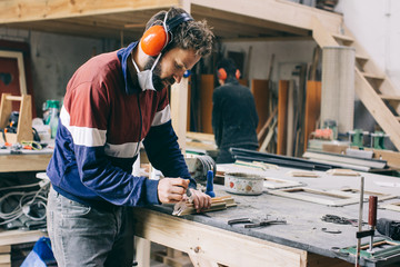 Picture Frame Making - Young Male Carpenter Applying Glue With Brush