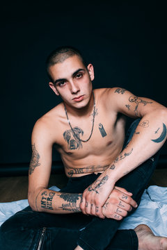 Tattooed young man portrait over black background
