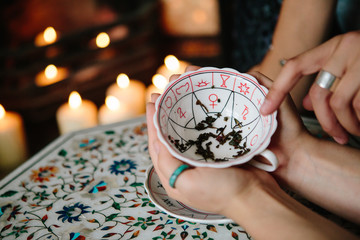 Woman fortune teller reading tea leaves